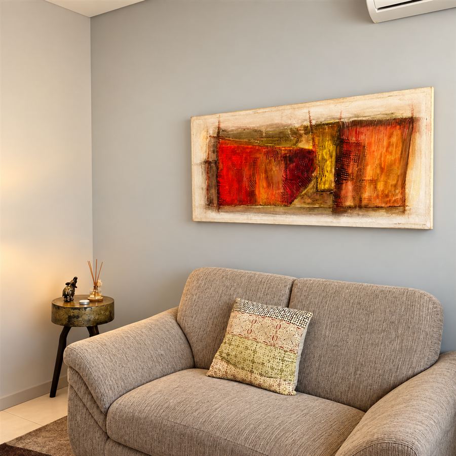 Sofá com almofada e quadro abstrato